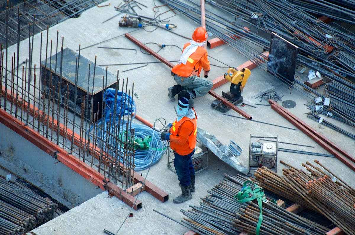 Construction worker on site with an active build in the background.